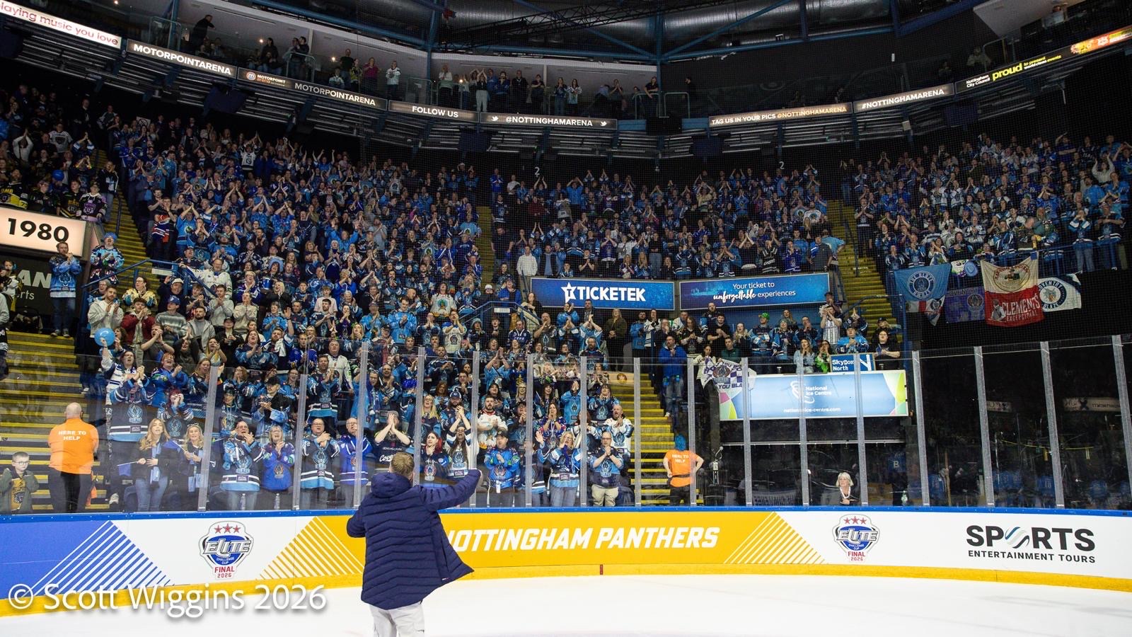 JD on the ice with his back to camera, waving to a packed arena of Blaze supporters
