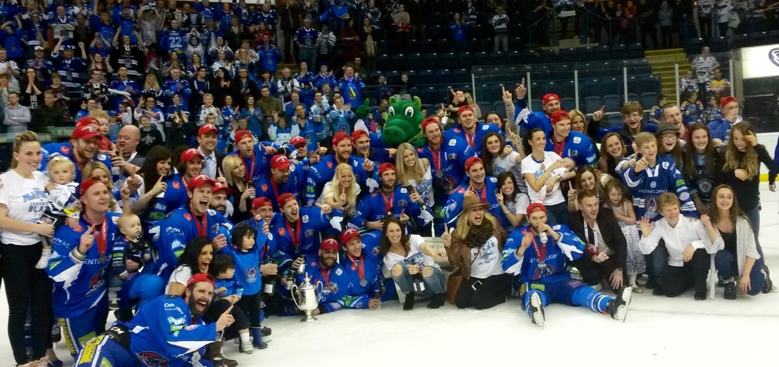 Coventry Blaze players, staff and families celebrating on the ice with the trophy